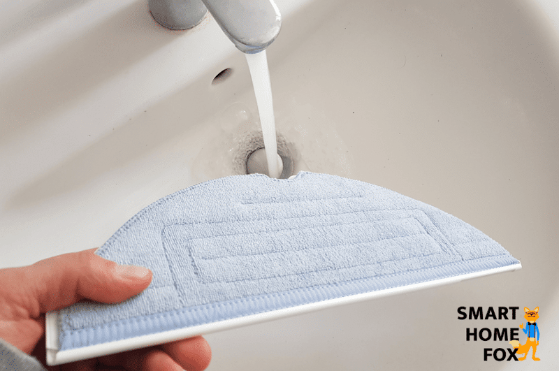 Der Wischmopp des Roborock S7 wird unter dem Wasserhahn vor dem Reinigungsbeginn nass gemacht